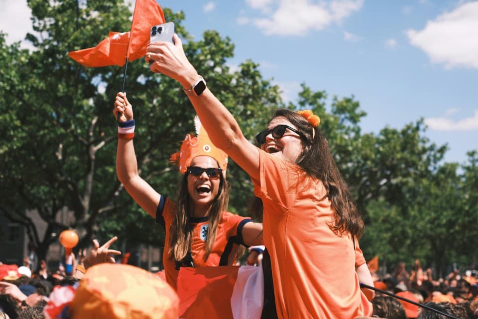 Mensen in oranje outfits die Koningsdag vieren